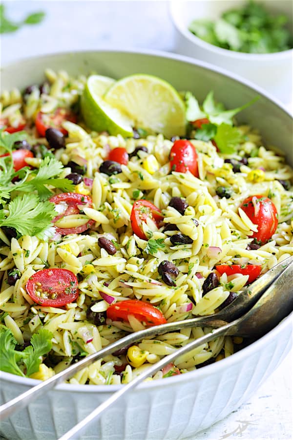 Close-up photo of Southwestern Orzo Salad with Cilantro Lime Dressing in white serving bowl. in serving bowl.