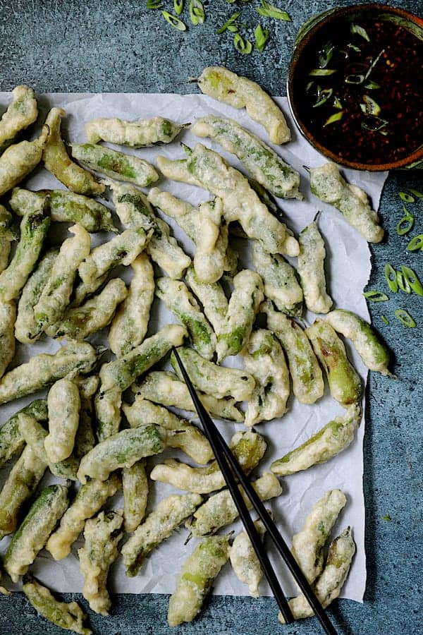 Photo of Beer Batter Shishito Pepper Tempura with Spicy Garlic Dipping Sauce garnished with thinly sliced scallions.