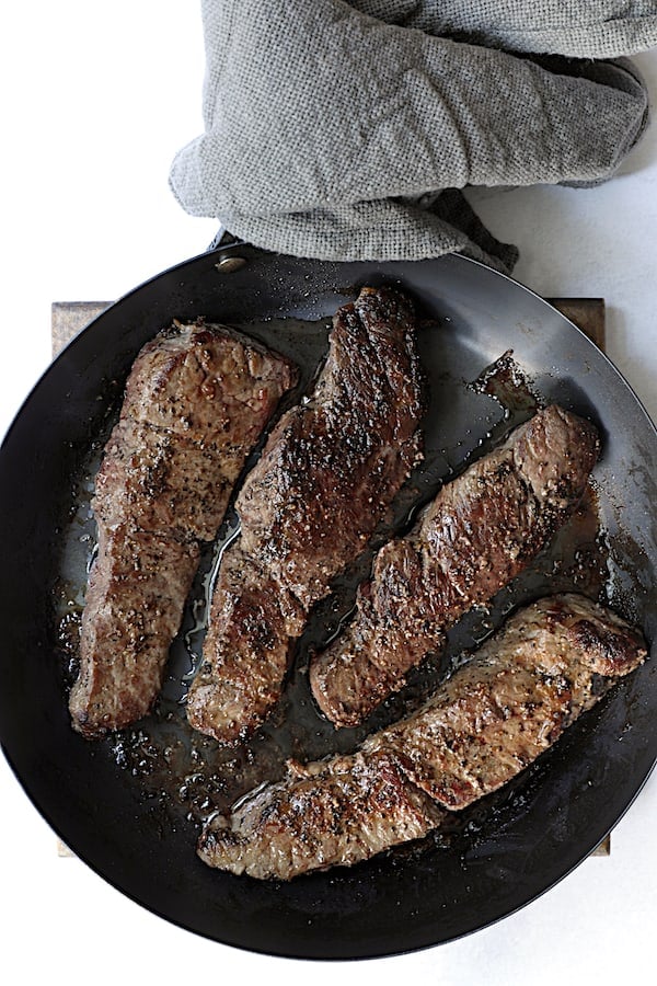 Photo of browned boneless short ribs in black skillet.