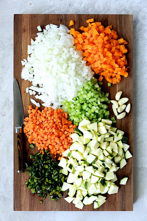 Photo of chopped vegetables on dark wood cutting board.