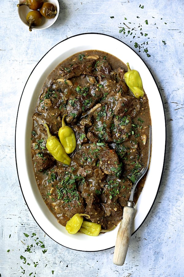 Photo of Mississippi-Style Boneless Short Ribs on white platter garnished with peppers and parsley.