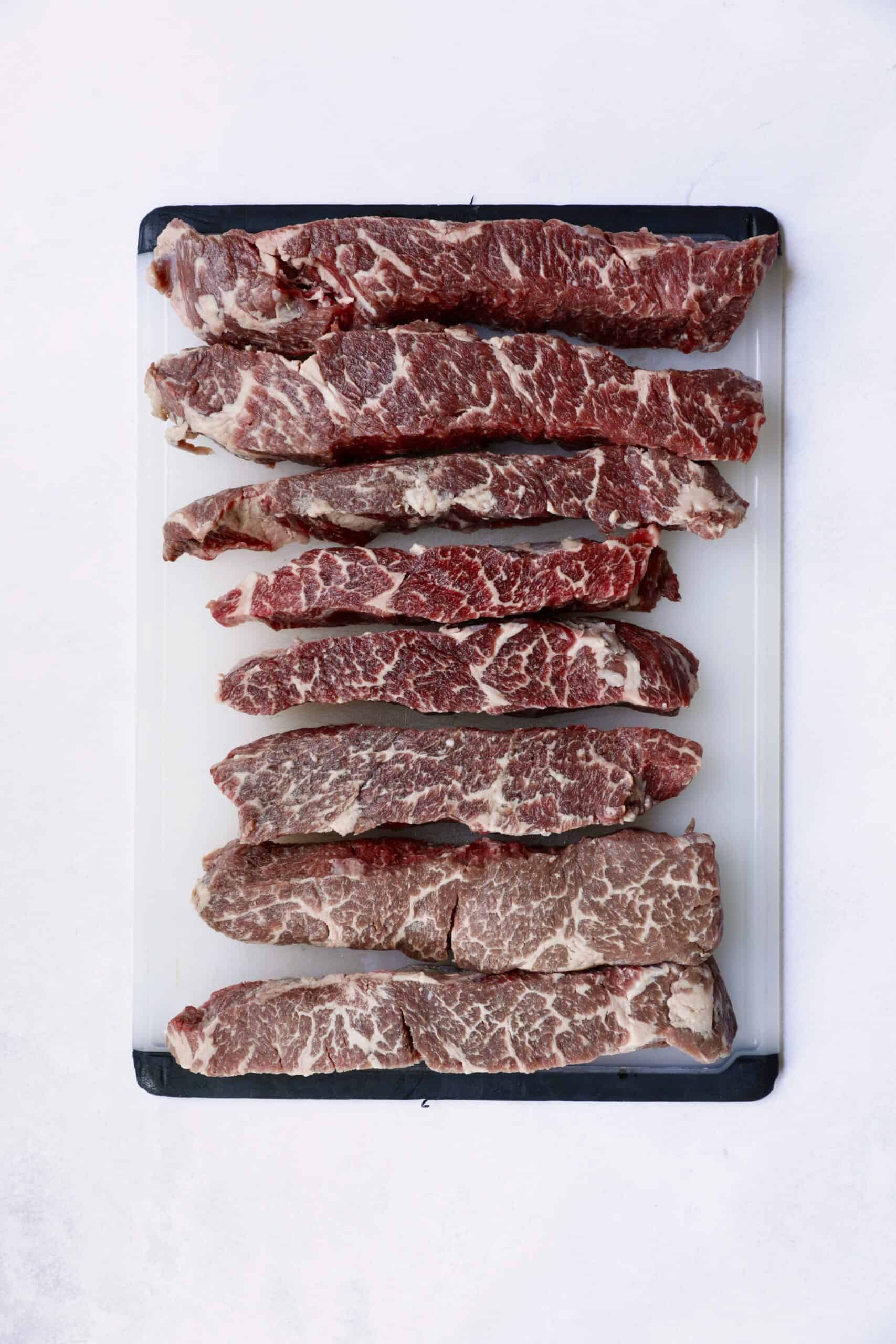 Overhead shot of boneless short ribs on white cutting board