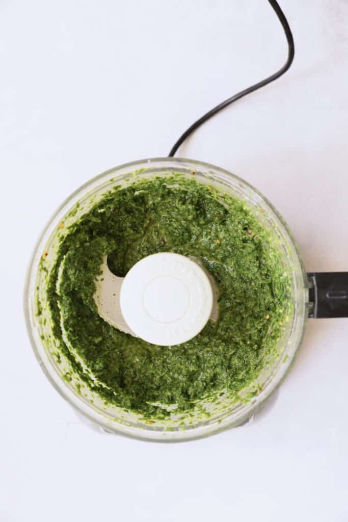 Photo of carrot top salsa verde in food processor after being pureed.