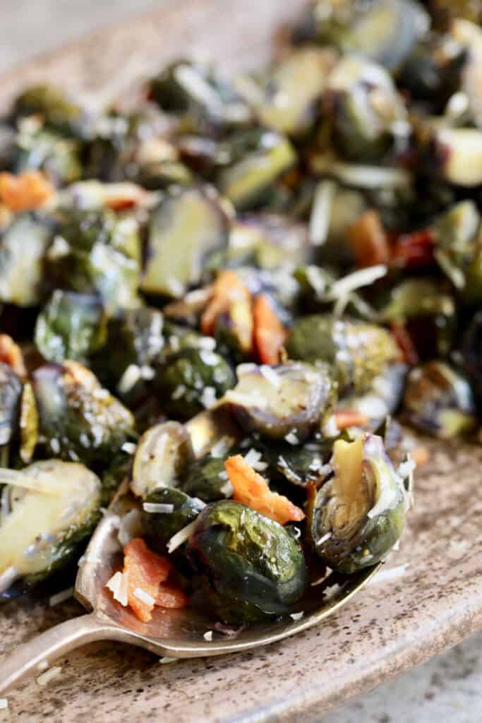Close-up photo of Roasted Purple Brussels Sprouts with Bacon and Parmesan on serving spoon.