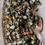 Roasted Purple Brussels Sprouts with Bacon and Parmesan - Overhead hero shot on brown platter