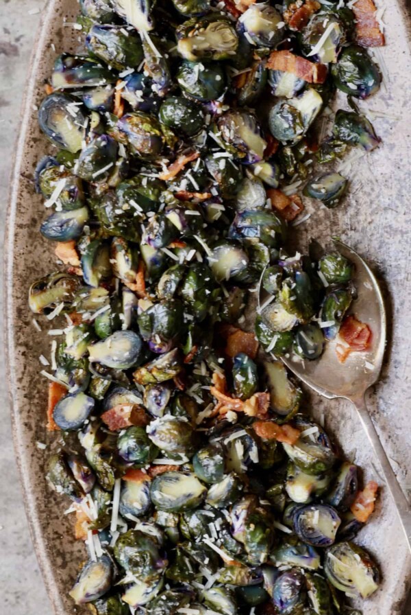 Roasted Purple Brussels Sprouts with Bacon and Parmesan - Overhead hero shot on brown platter