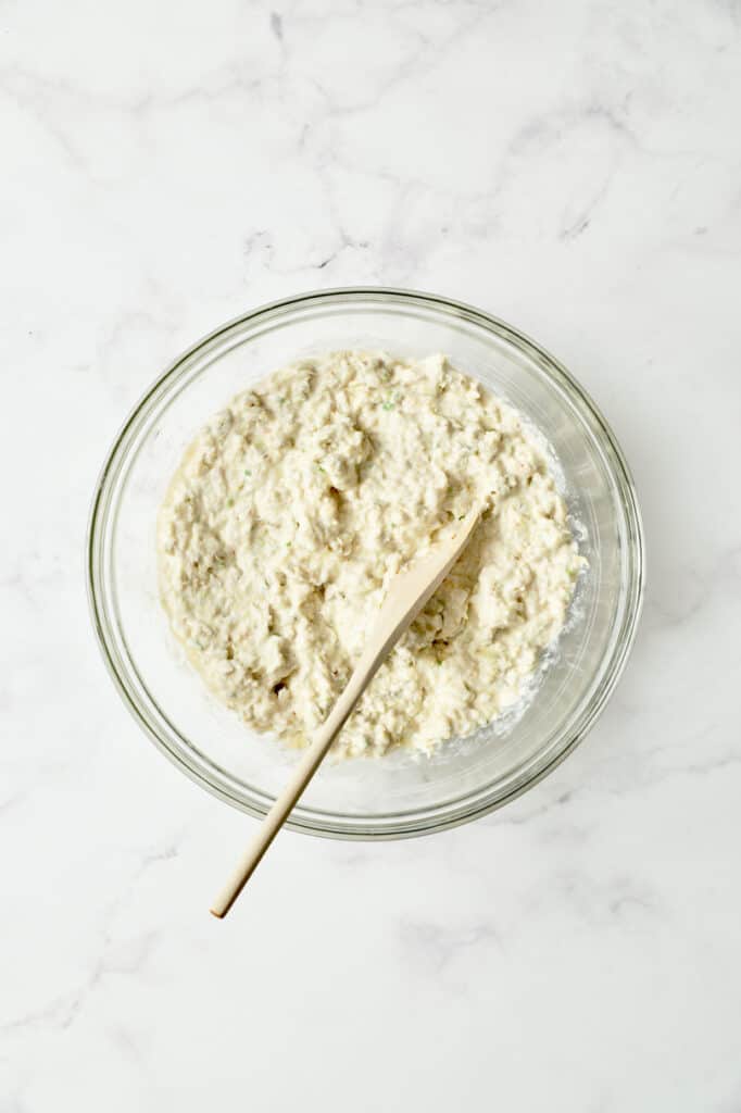 Photo of beignet batter combined in glass bowl.