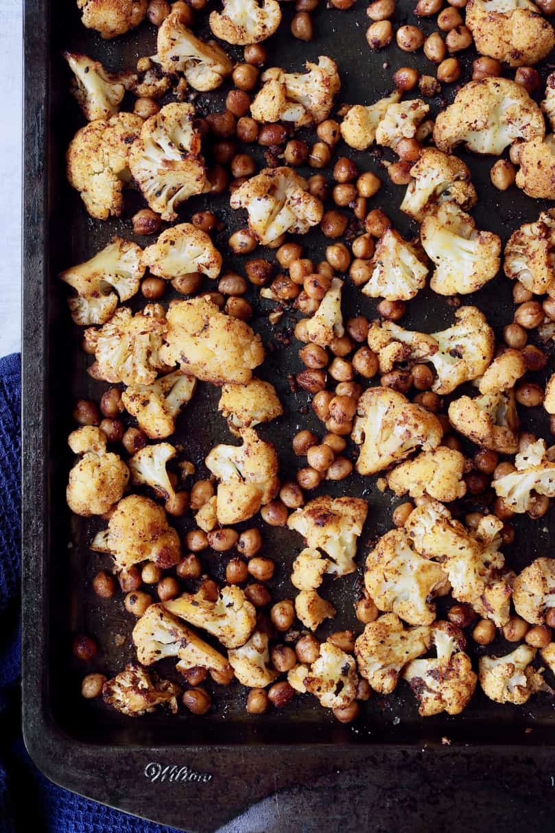 Close-up photo of roasted cauliflower and chickpeas on baking sheet.