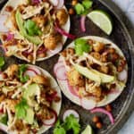Overhead close-up shot of three tacos on round platter