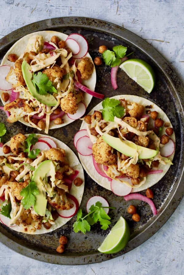 Overhead close-up shot of three tacos on round platter