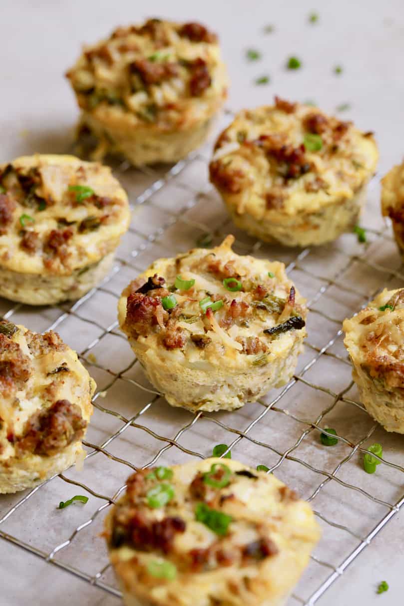 Photo of Hash Brown Breakfast Muffins with Poblano Peppers and Gouda Cheese on cooling rack garnished with chives.