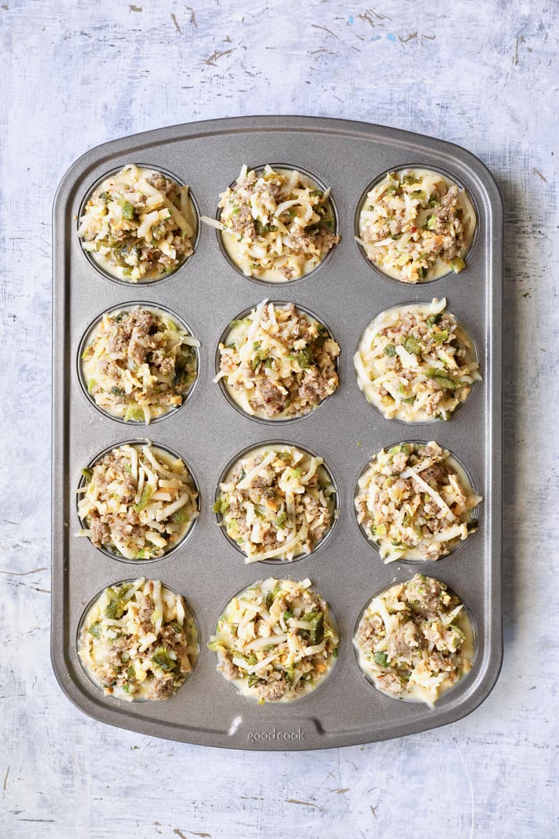 Photo of meat, potato and cheese combination added to muffin pan before baking.