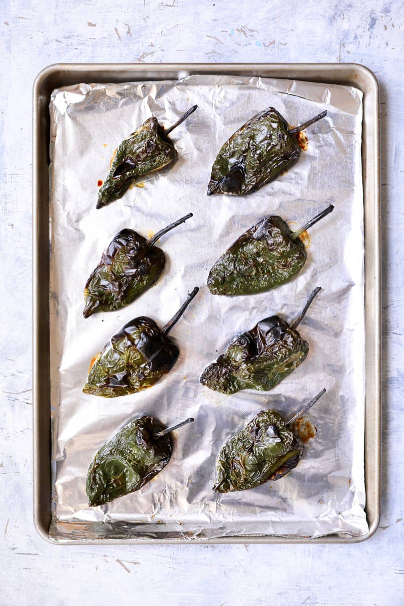 Photo of roasted Poblano peppers on foil-lined baking sheet.