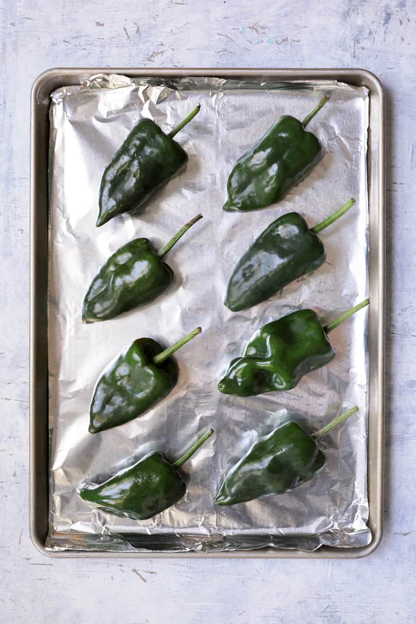 Photo of fresh Poblanos on foil-lined baking sheet about to be roasted.