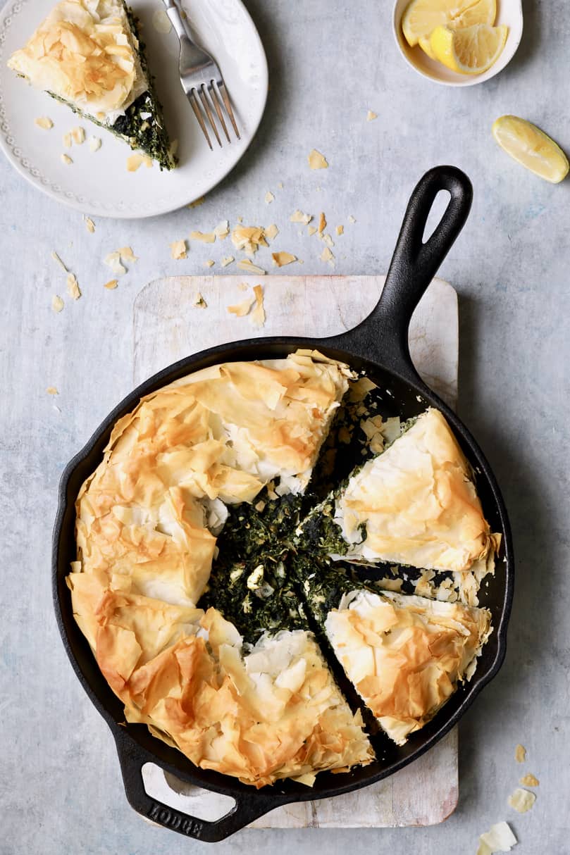 Photo of Skillet Spanakopita (Greek Spinach and Feta Pie) with a piece removed to a plate.