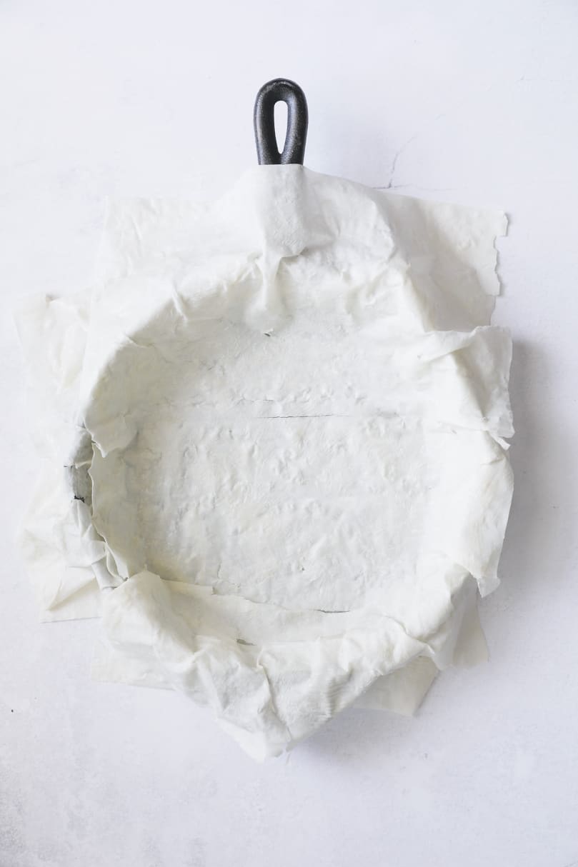 Photo of phyllo dough over the bottom of a cast iron skillet.
