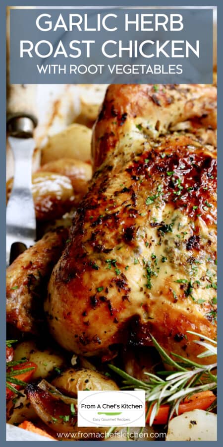 Garlic Herb Butter Roast Chicken with root vegetables in white roasting pan garnished with fresh rosemary.