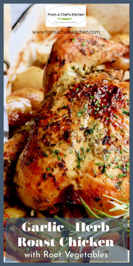 Garlic Herb Butter Roast Chicken with root vegetables in white roasting pan garnished with fresh rosemary.