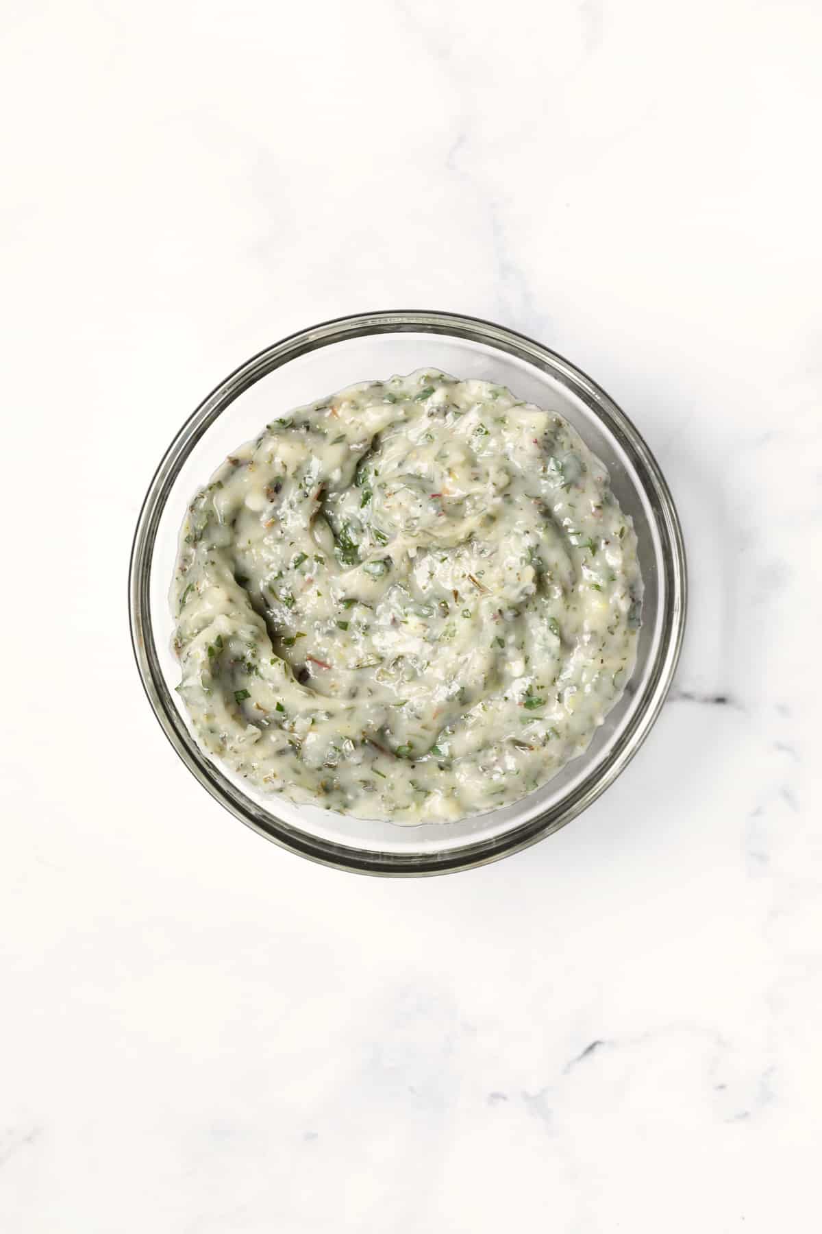 Photo of Garlic Herb Butter in glass bowl on white background.