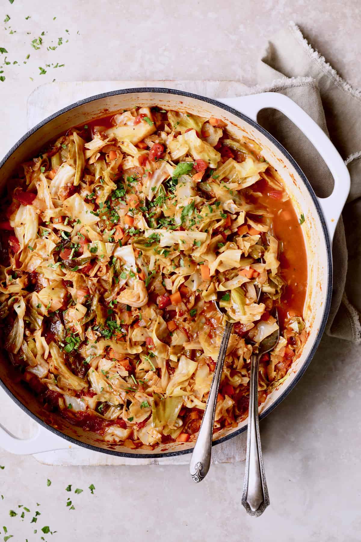 Photo of Polish Stewed Cabbage (Kapusta) in white cast iron pan.