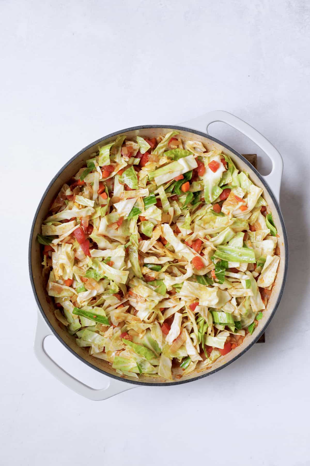 Photo of uncooked cabbage added to pan.