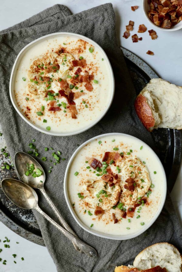 Photo of Cauliflower Potato Soup with Smoked Gouda on gray napkin on round platter.