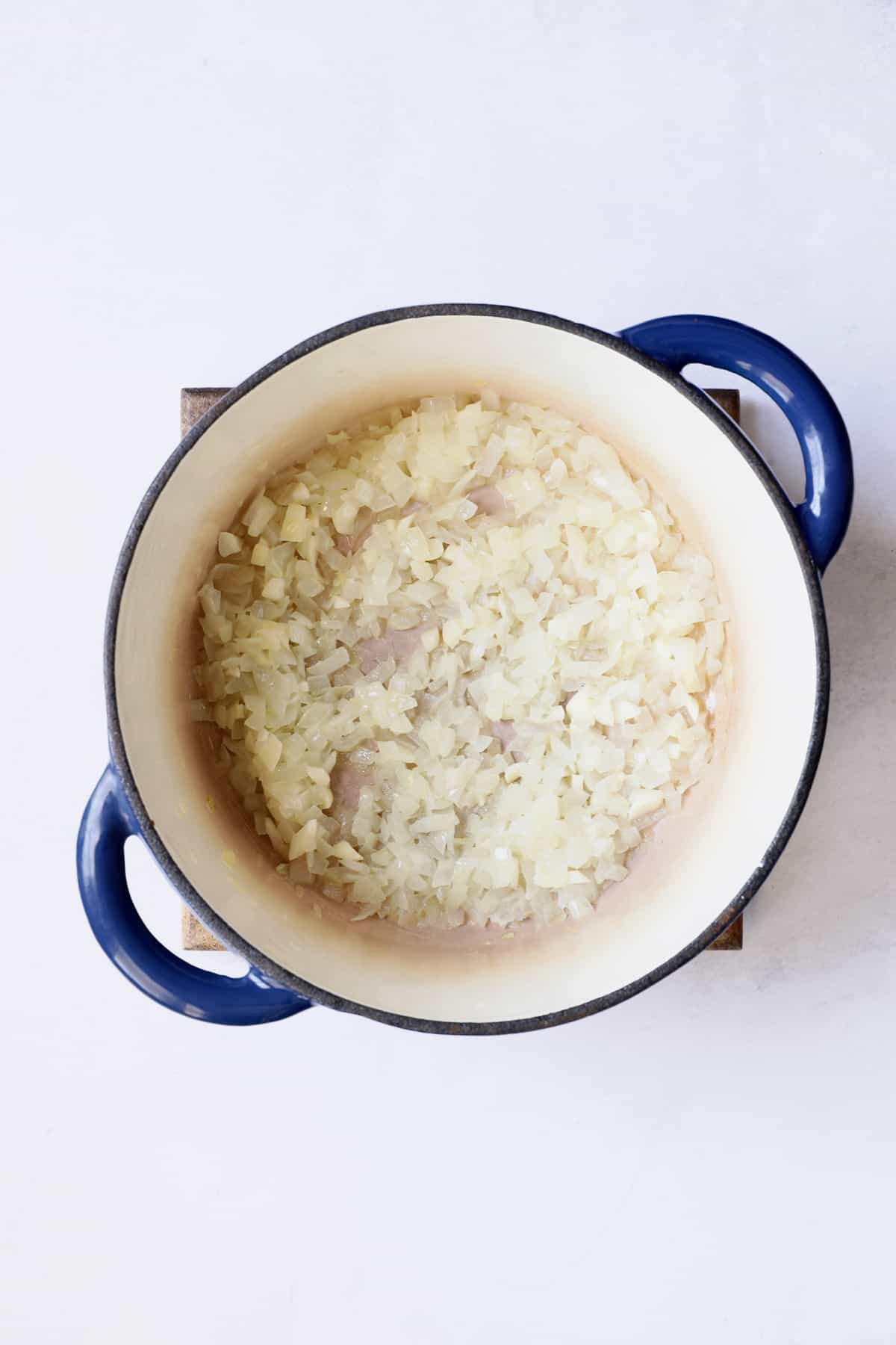 Cooked onions in blue Dutch oven.