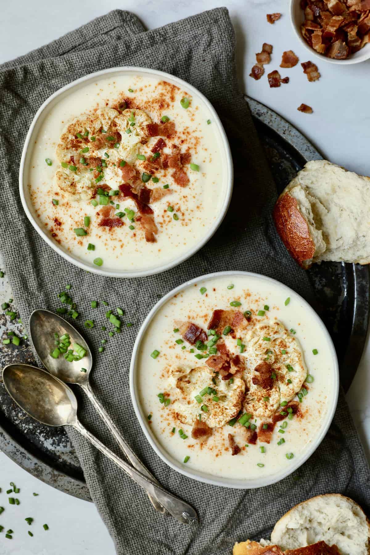 Cauliflower Potato Soup with Smoked Gouda on gray napkin on round platter.