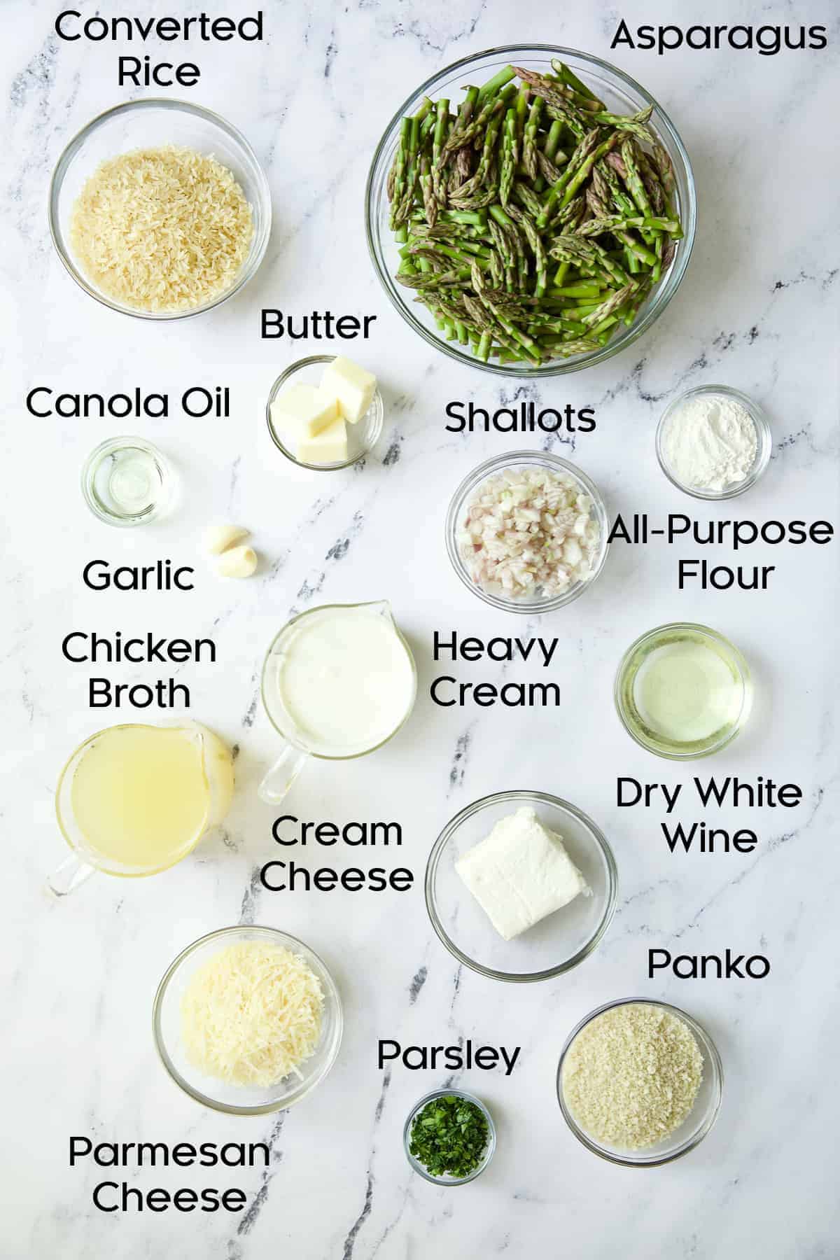 Photo of ingredients for Creamy Asparagus and Rice Casserole in glass bowls on marble background.