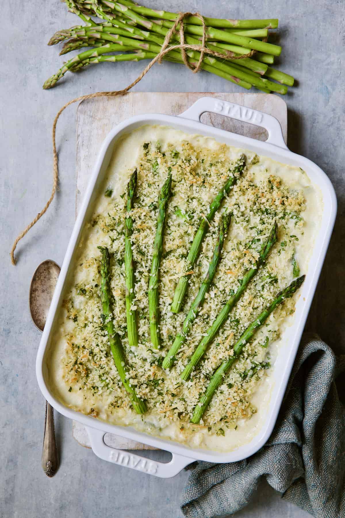 Photo of Creamy Asparagus and Rice Casserole with serving spoon and asparagus tied with twine.