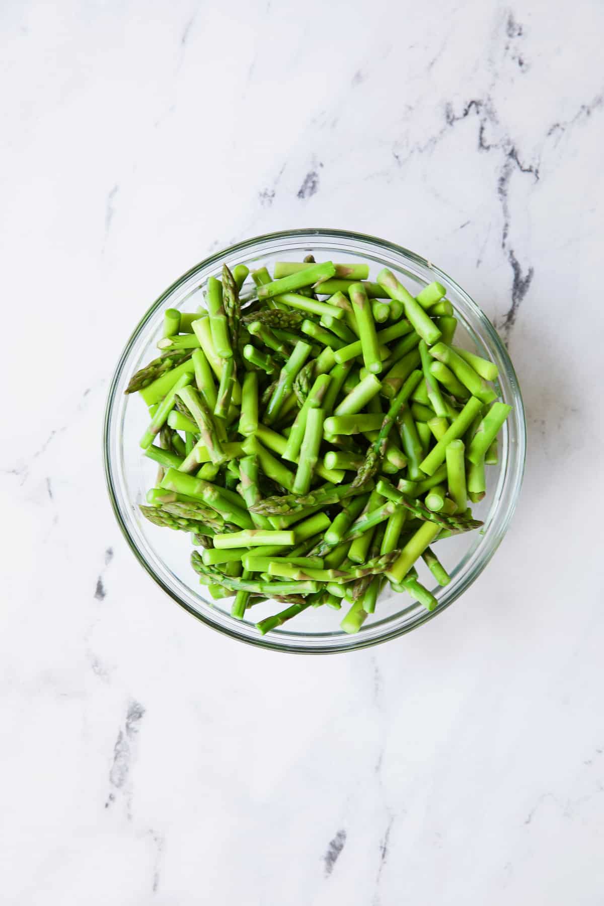 Photo of blanched asparagus in glass bowl.