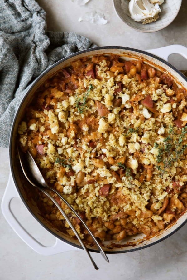 Photo of Easy Weeknight Chicken and Sausage Cassoulet with gray napkin and serving utensils.