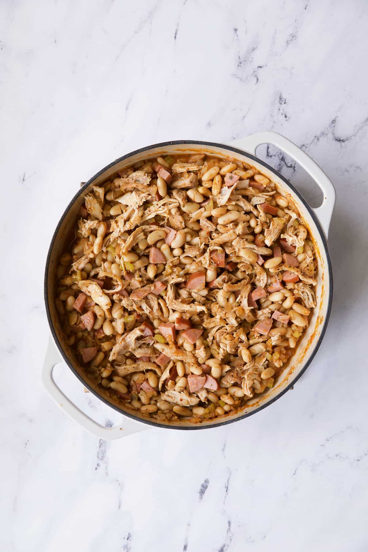Photo of cassoulet on white marble surface before breadcrumbs are added.