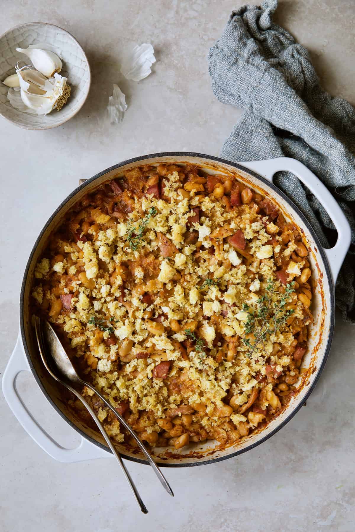 Photo of Easy Weeknight Chicken and Sausage Cassoulet with serving utensils.