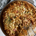 Photo of Easy Weeknight Chicken and Sausage Cassoulet after some has been served with serving utensils.