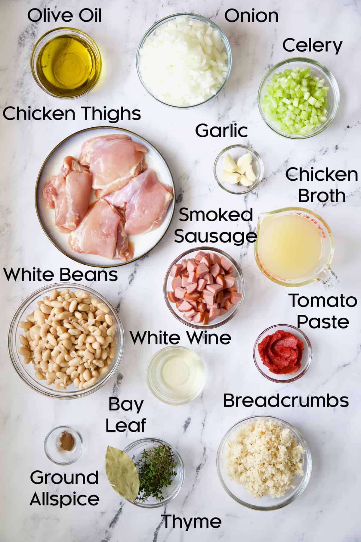 Photo of ingredients for Easy Weeknight Chicken and Sausage Cassoulet in glass bowls.