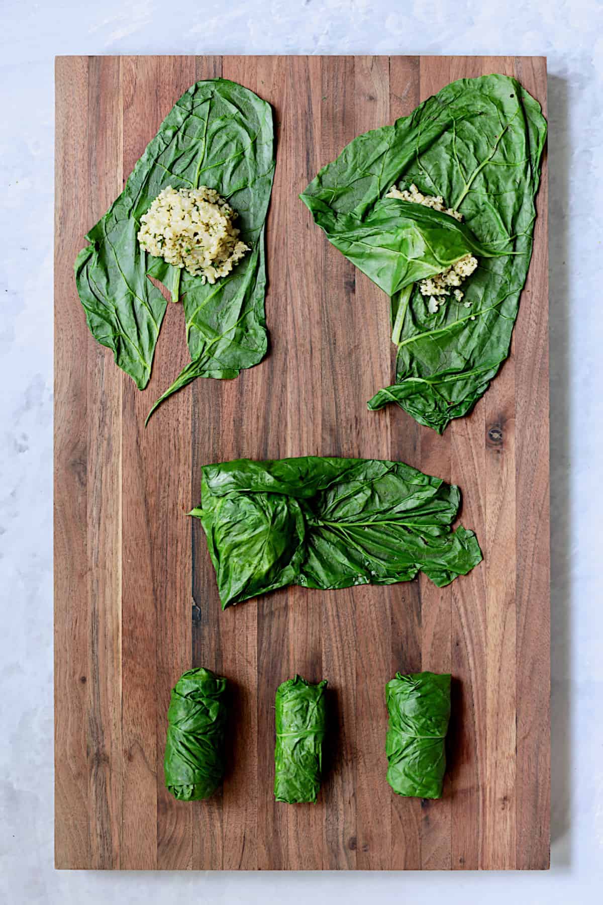 Photo showing how to enclose quinoa filling in Swiss chard leaves.