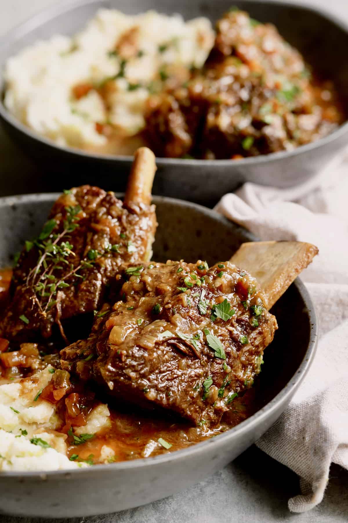 Close-up photo of Stout Braised Beef Short Ribs and Colcannon in gray bowl.