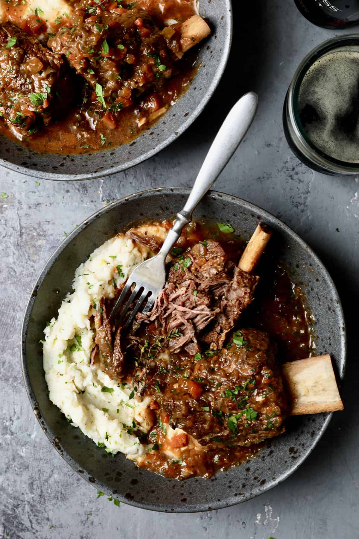 Photo of Stout Braised Beef Short Ribs and Colcannon with fork shredding one of the short ribs.