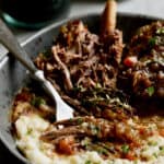 Close-up photo of Stout Braised Beef Short Ribs and Colcannon with fork shredding one of the short ribs.
