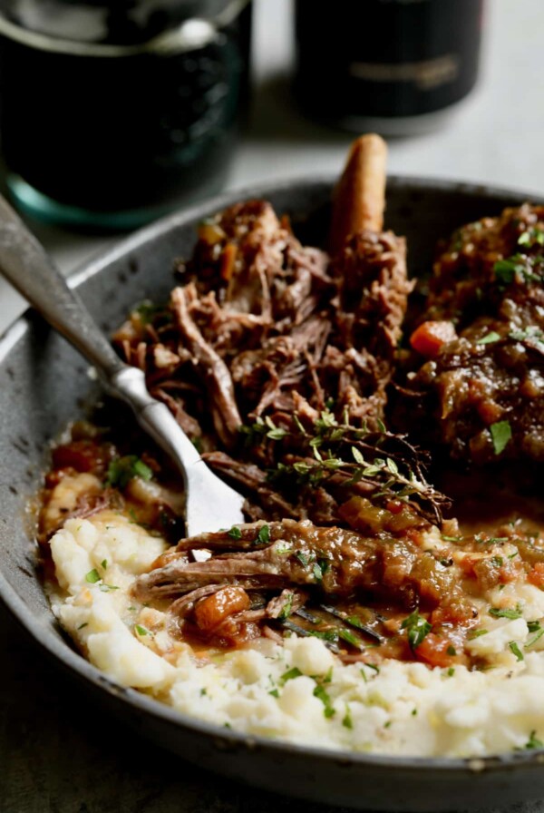 Close-up photo of Stout Braised Beef Short Ribs and Colcannon with fork shredding one of the short ribs.