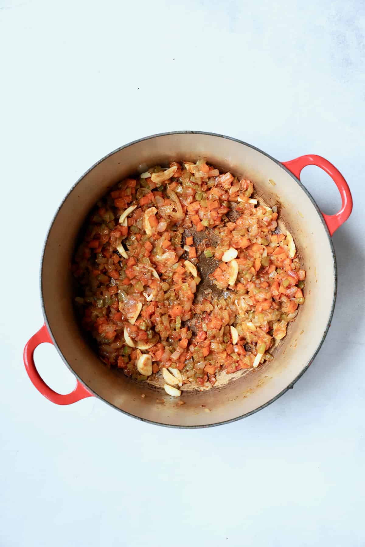 Photo of cooked onions, celery and carrots with flour and tomato paste added.