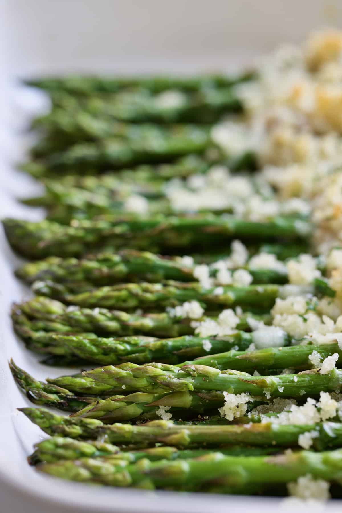 Close-up photo of Asparagus Cordon Bleu in white baking dish.