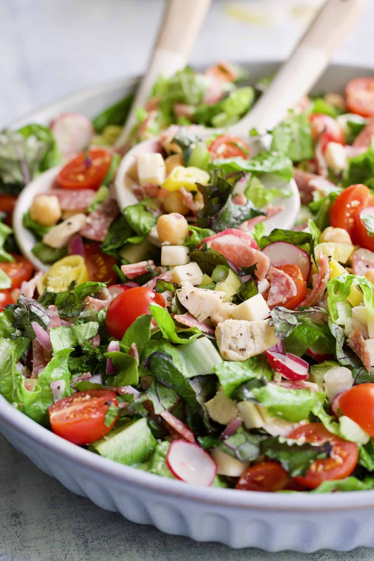Close-up photo of Italian Chopped Salad with Chicken with serving utensils.