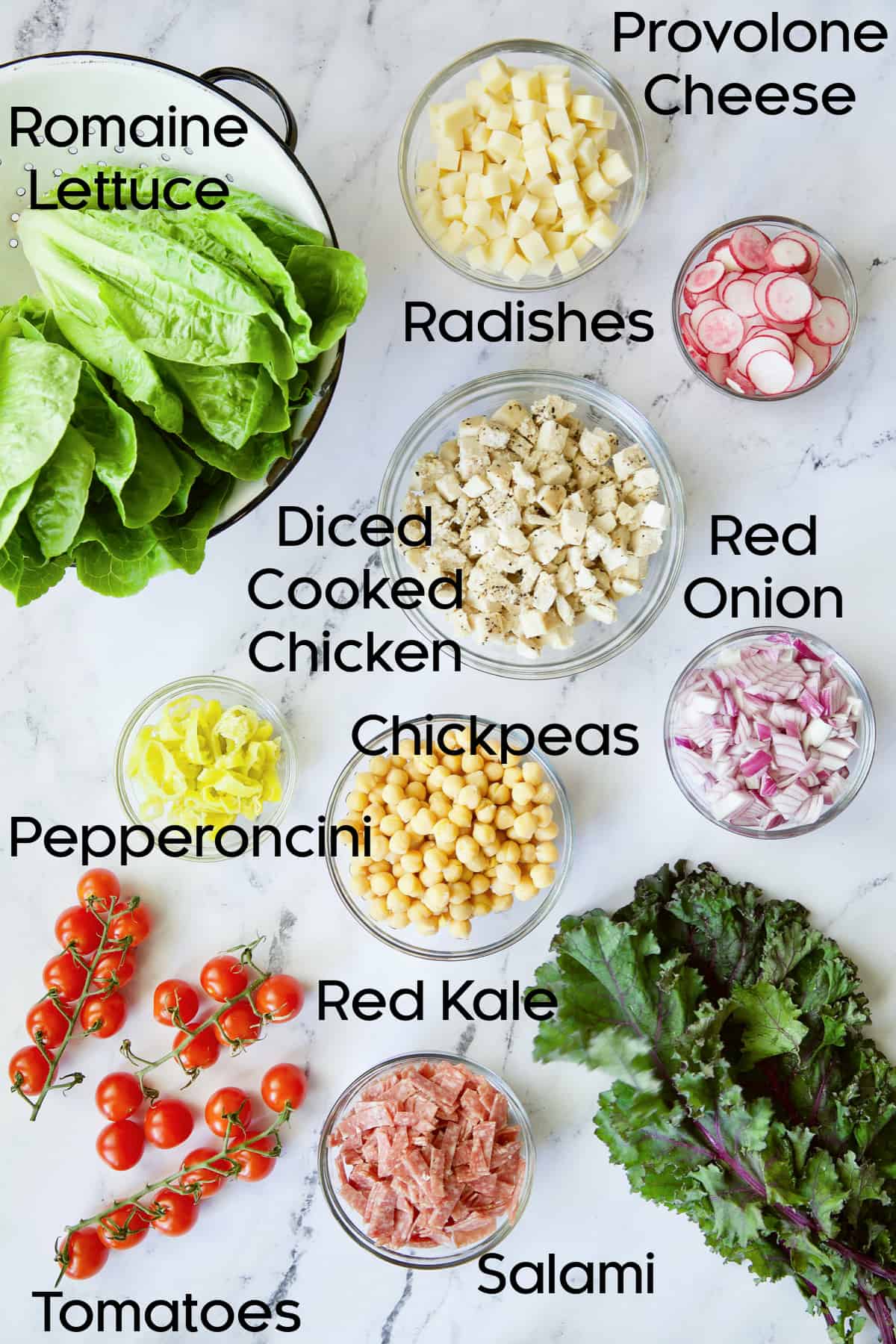Photo of ingredients for Italian Chopped Salad with Chicken in glass bowls.
