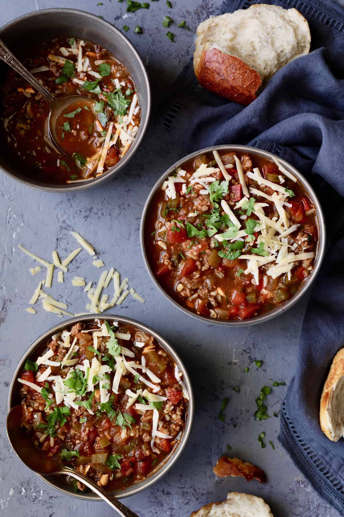 Photo of three bowls of Southwestern Stuffed Pepper Soup with bread.