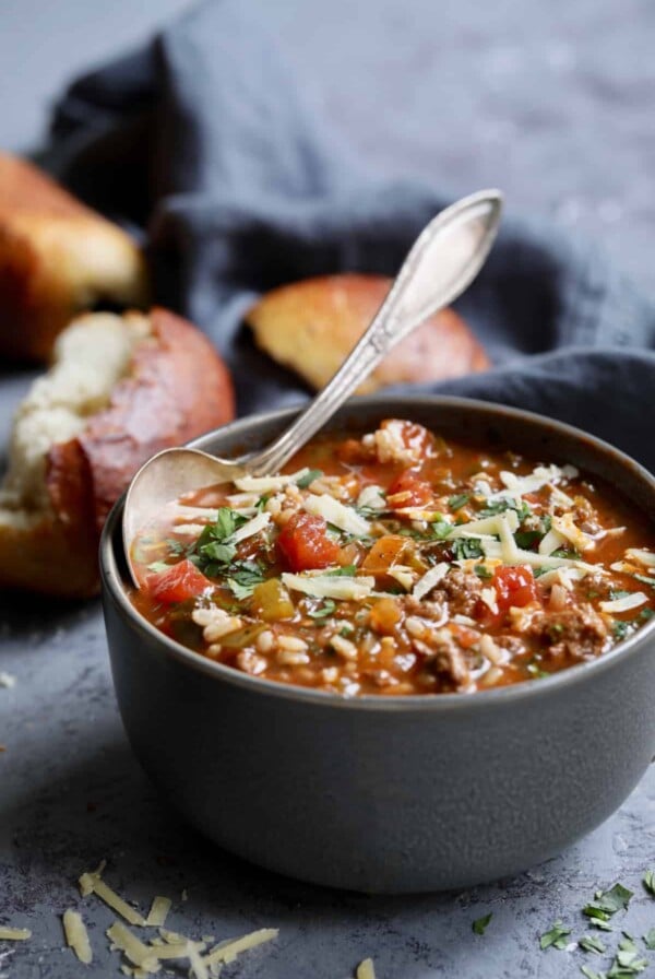 Photo of a bowl of Southwestern Stuffed Pepper Soup on blue background with bread.