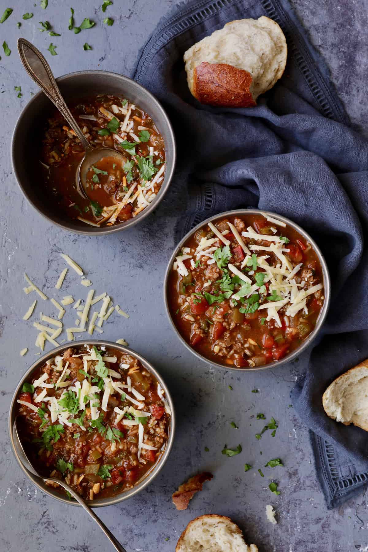 Photo of three bowls of Southwestern Stuffed Pepper Soup with two full and one half eaten.