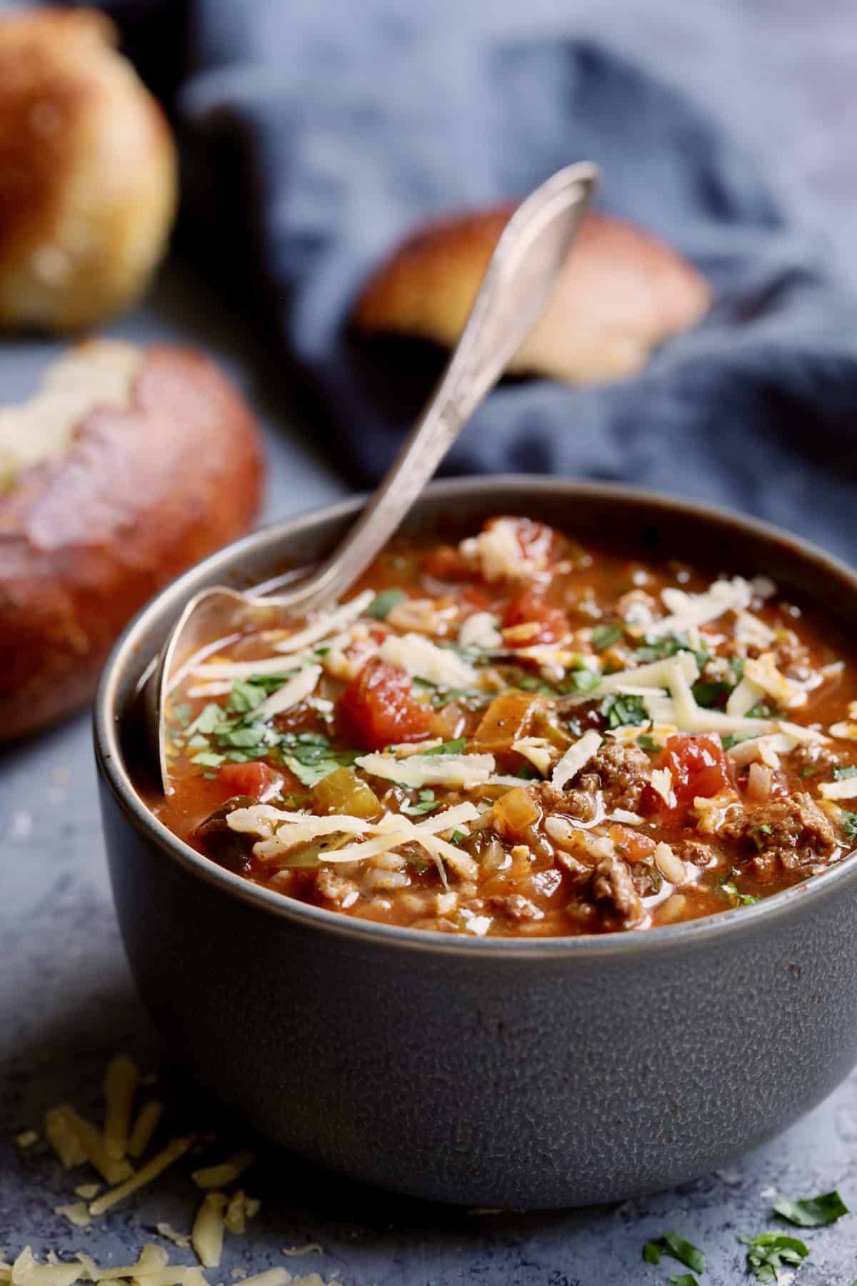 Photo of a bowl of Southwestern Stuffed Pepper Soup with spoon and bread in the background.