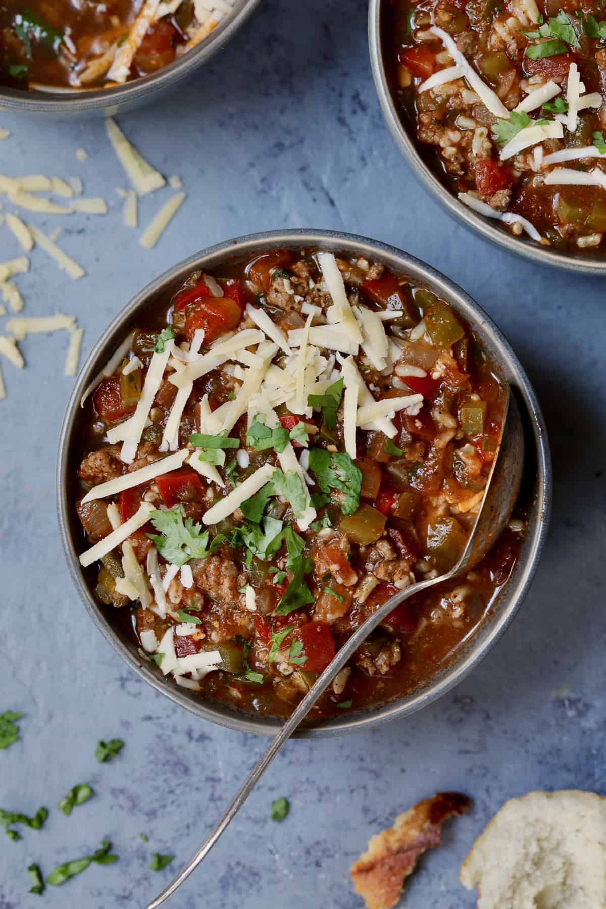 Photo of Southwestern Stuffed Pepper Soup in gray bowl garnished with cheese and cilantro.